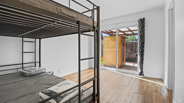 unfurnished bedroom with access to outside and light hardwood / wood-style flooring