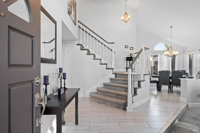 foyer featuring a towering ceiling, light tile patterned flooring, and a chandelier