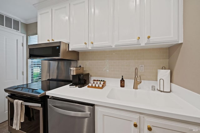 kitchen with light countertops, appliances with stainless steel finishes, decorative backsplash, and white cabinets