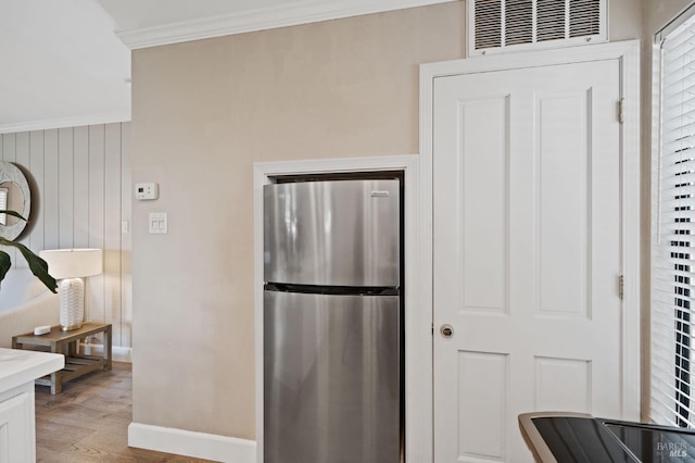 kitchen with visible vents, ornamental molding, freestanding refrigerator, light wood-type flooring, and baseboards