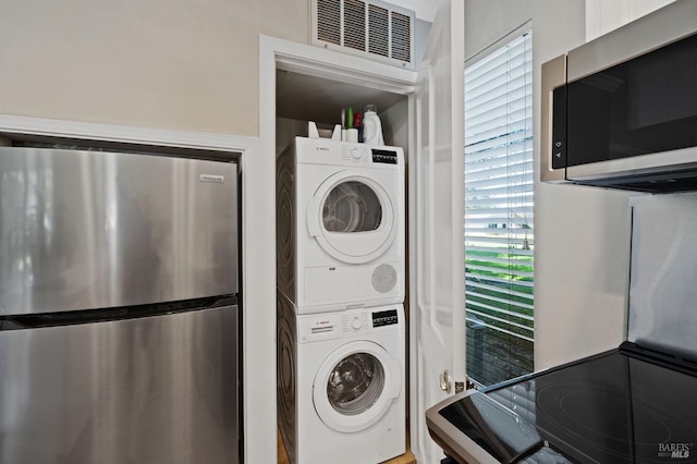 laundry room with stacked washer / drying machine, laundry area, and visible vents