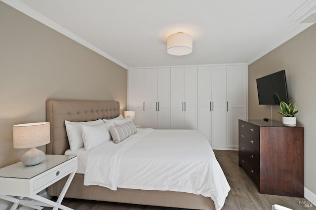 bedroom featuring ornamental molding and wood finished floors