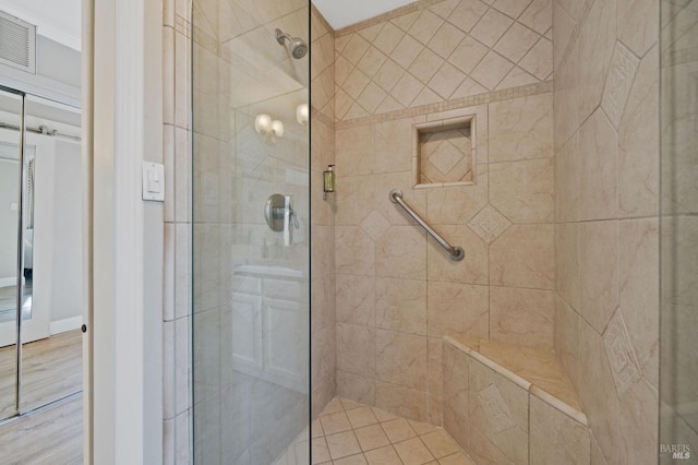 bathroom with a shower stall and visible vents