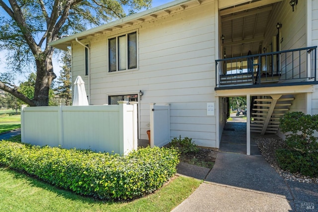 view of home's exterior featuring fence and stairway