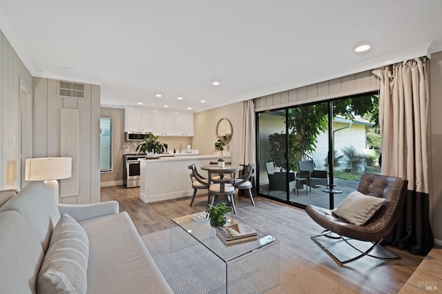 living room with recessed lighting, light wood-type flooring, visible vents, and crown molding