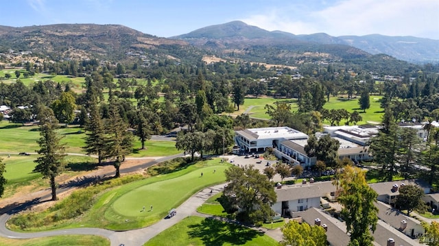 aerial view with view of golf course and a mountain view