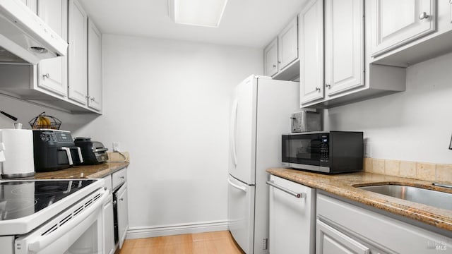 kitchen featuring white cabinetry, light stone countertops, sink, light hardwood / wood-style flooring, and white appliances