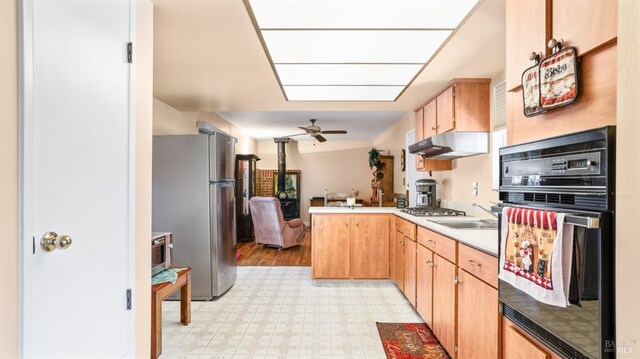 kitchen featuring kitchen peninsula, stainless steel appliances, ceiling fan, sink, and light brown cabinets