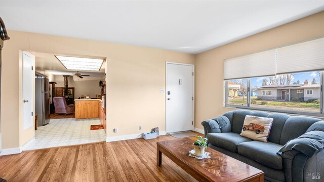 living room with a skylight and light hardwood / wood-style flooring