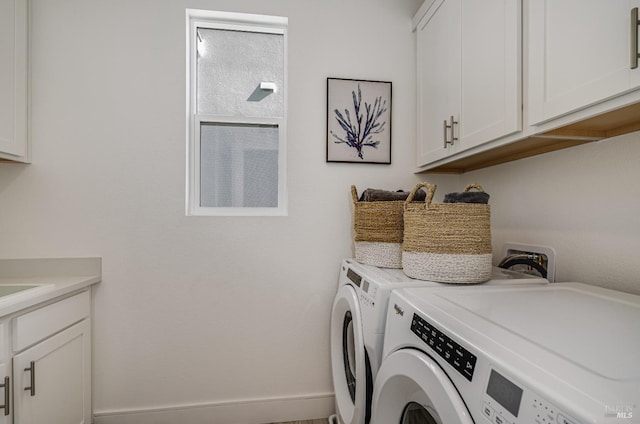 laundry room with washer and dryer and cabinets