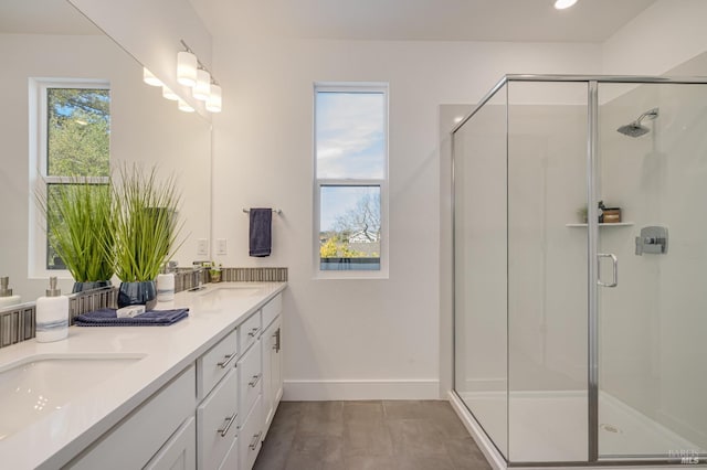 bathroom with vanity, a healthy amount of sunlight, and a shower with shower door