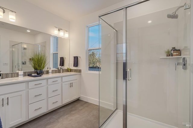 bathroom featuring vanity and a shower with door