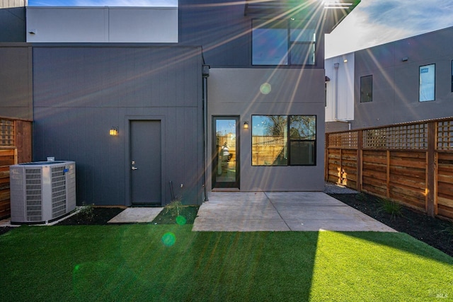 rear view of house featuring a yard, a patio, and cooling unit