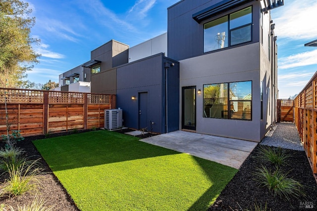 back of property with a lawn, a patio area, and central air condition unit