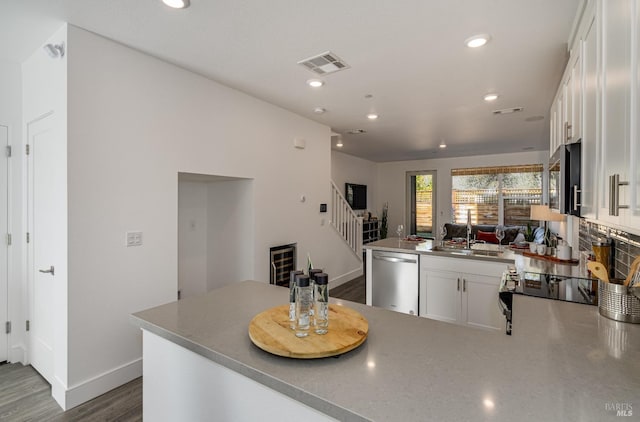 kitchen with stainless steel appliances, white cabinetry, dark wood-type flooring, and sink