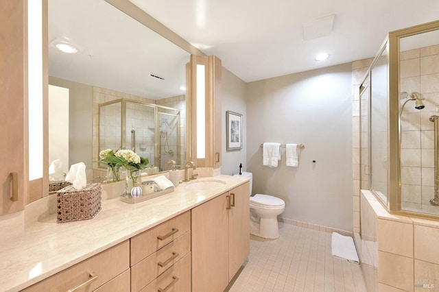 bathroom featuring toilet, tile patterned flooring, a shower with door, and vanity