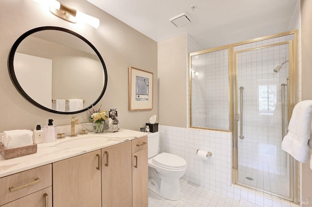 bathroom with tile walls, toilet, walk in shower, tile patterned floors, and vanity