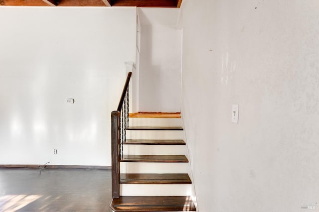 stairs with finished concrete floors and baseboards