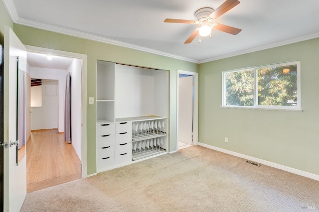 unfurnished bedroom featuring visible vents, baseboards, ornamental molding, carpet, and a closet