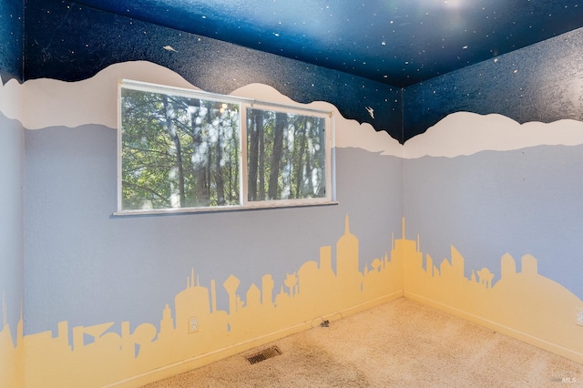 carpeted spare room featuring baseboards and visible vents