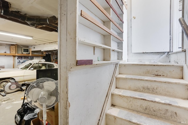 staircase with unfinished concrete floors