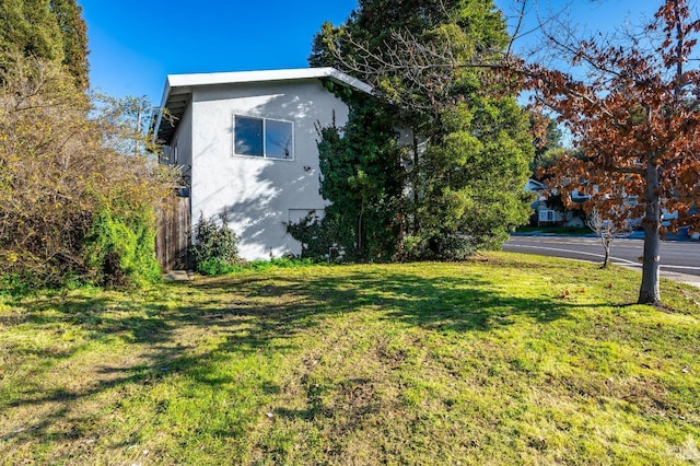 view of side of home featuring a yard and stucco siding