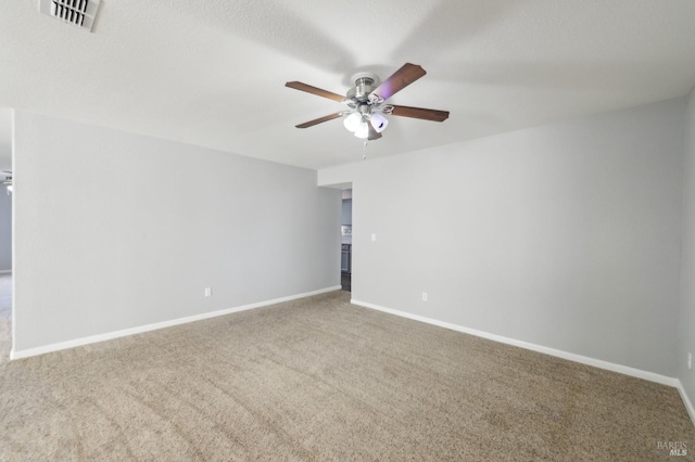 unfurnished room featuring ceiling fan, carpet flooring, visible vents, and baseboards