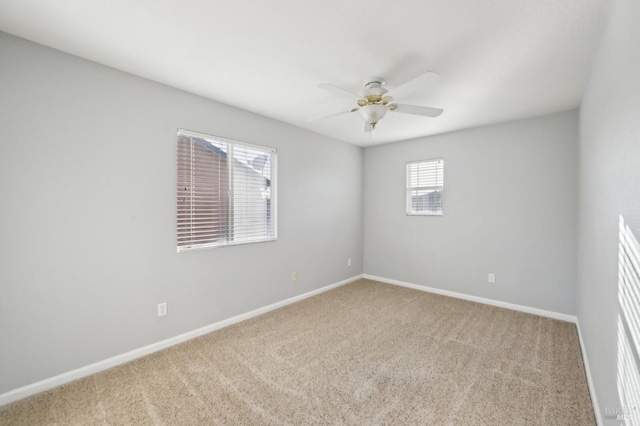 carpeted empty room featuring ceiling fan and baseboards