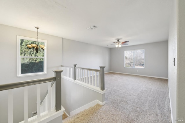 corridor with visible vents, carpet floors, an upstairs landing, and baseboards