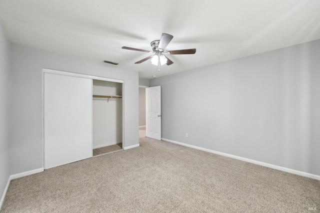 unfurnished bedroom with ceiling fan, visible vents, baseboards, a closet, and carpet