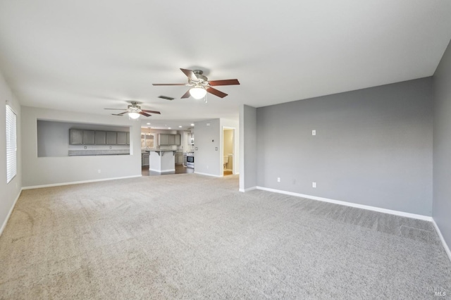 unfurnished living room with visible vents, baseboards, a ceiling fan, and light colored carpet