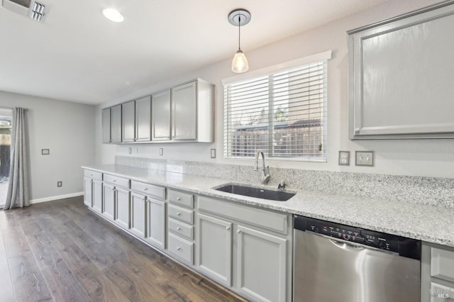 kitchen with a sink, visible vents, baseboards, dishwasher, and dark wood finished floors