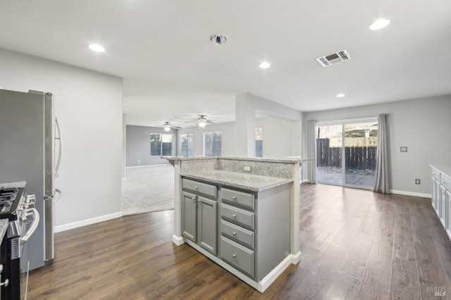 kitchen featuring dark wood-style floors, gray cabinets, visible vents, and stainless steel range with gas stovetop