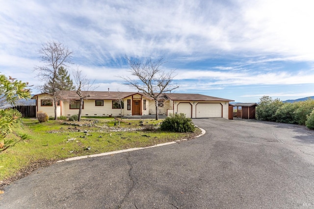 single story home with a front yard and a garage