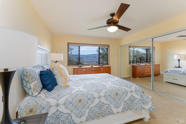 carpeted bedroom with ceiling fan and a closet