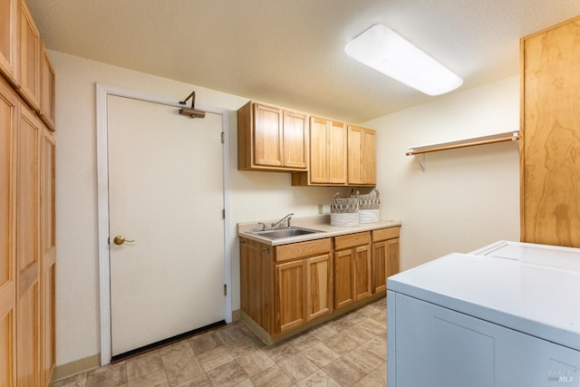 washroom featuring washer and dryer, cabinets, and sink