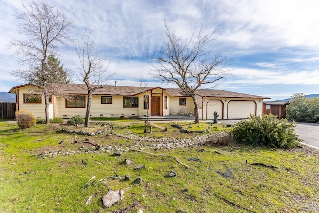 ranch-style house featuring a garage and a front lawn