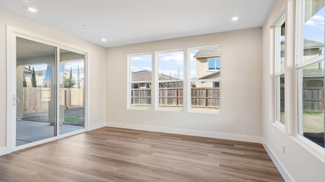 empty room featuring baseboards, wood finished floors, and recessed lighting