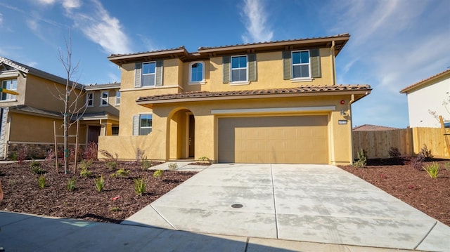 mediterranean / spanish-style house with a garage, a tile roof, fence, driveway, and stucco siding