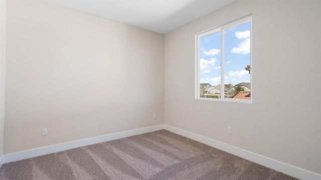 carpeted empty room with baseboards