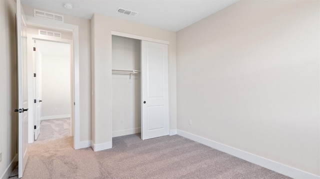 unfurnished bedroom featuring a closet, visible vents, baseboards, and carpet flooring