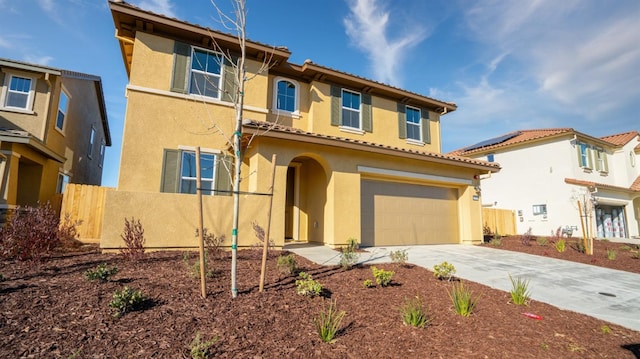 mediterranean / spanish home featuring stucco siding, an attached garage, fence, driveway, and a tiled roof