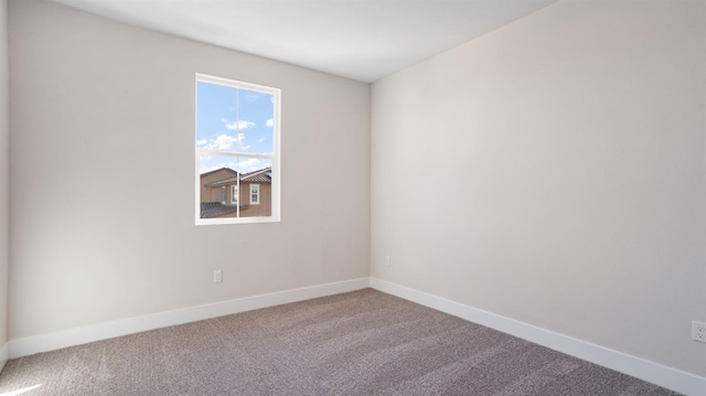 unfurnished room featuring carpet and baseboards