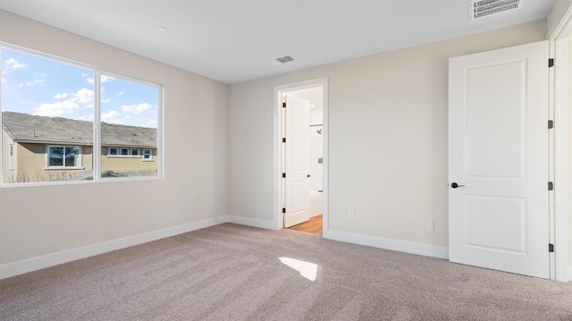 carpeted empty room featuring baseboards and visible vents