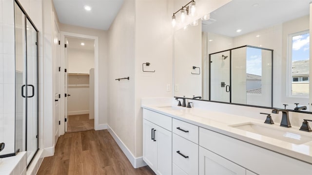 bathroom with a stall shower, a walk in closet, and a sink