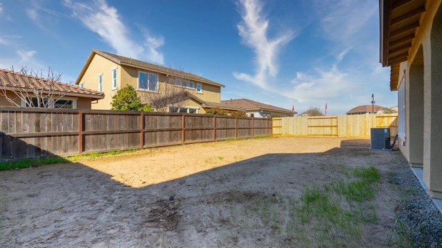 view of yard with a fenced backyard and central air condition unit