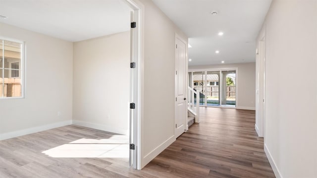 hallway featuring stairway, recessed lighting, wood finished floors, and baseboards