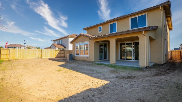 back of property featuring a patio, stucco siding, a fenced backyard, and central air condition unit