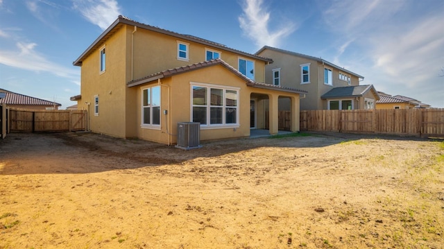 back of house featuring cooling unit, a tile roof, a fenced backyard, and stucco siding