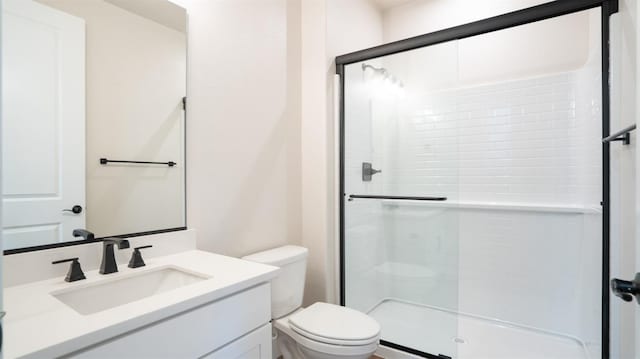 bathroom featuring a stall shower, vanity, and toilet